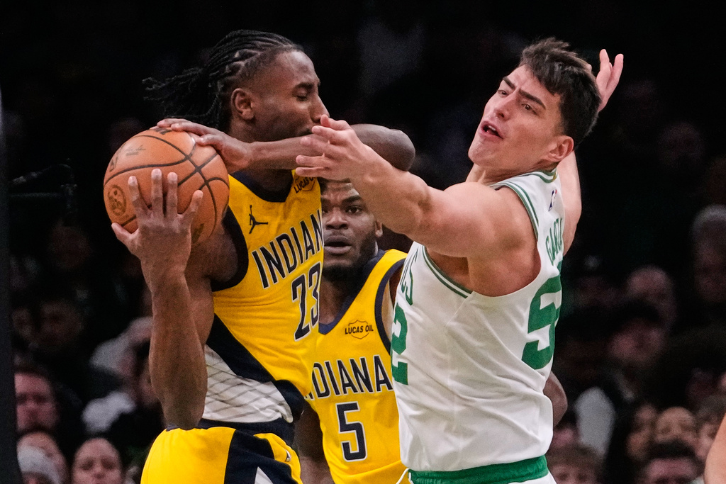Boston Celtics center Luka Garza (52) pressures Indiana Pacers guard Aaron Nesmith (23) during the first half of an NBA basketball game, Wednesday, Jan. 21, 2026, in Boston. (AP Photo/Charles Krupa)