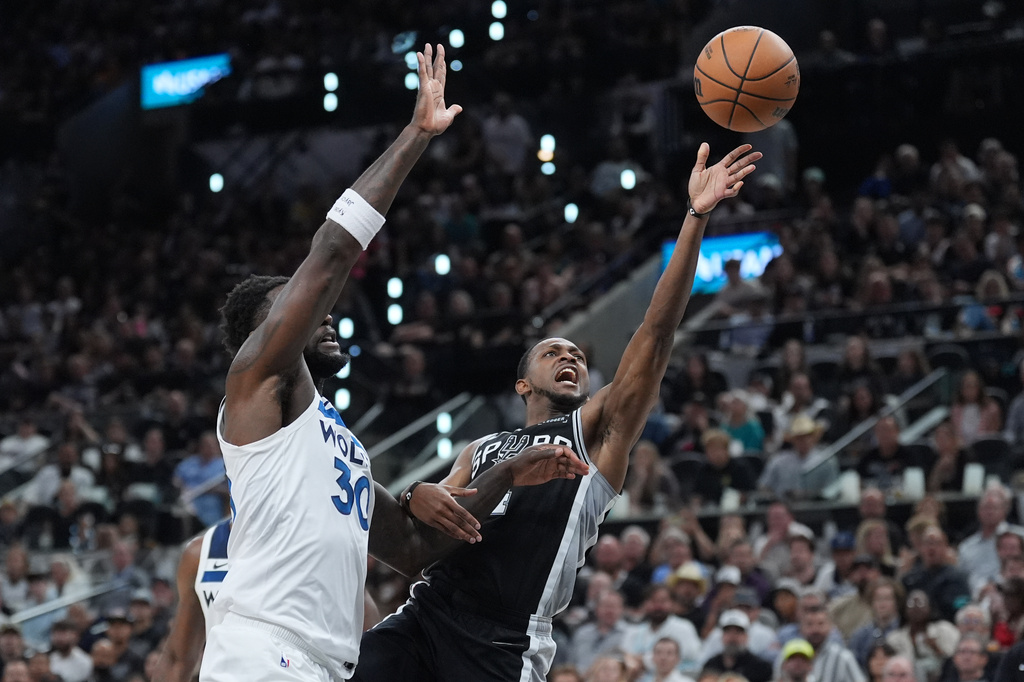 San Antonio Spurs guard De'aaron Fox (4) scores past Minnesota Timberwolves forward Julius Randle (30) during the first half of Game 5 of an NBA basketball second-round playoffs series in Minneapolis, Tuesday, May 12, 2026. (AP Photo/Eric Gay)