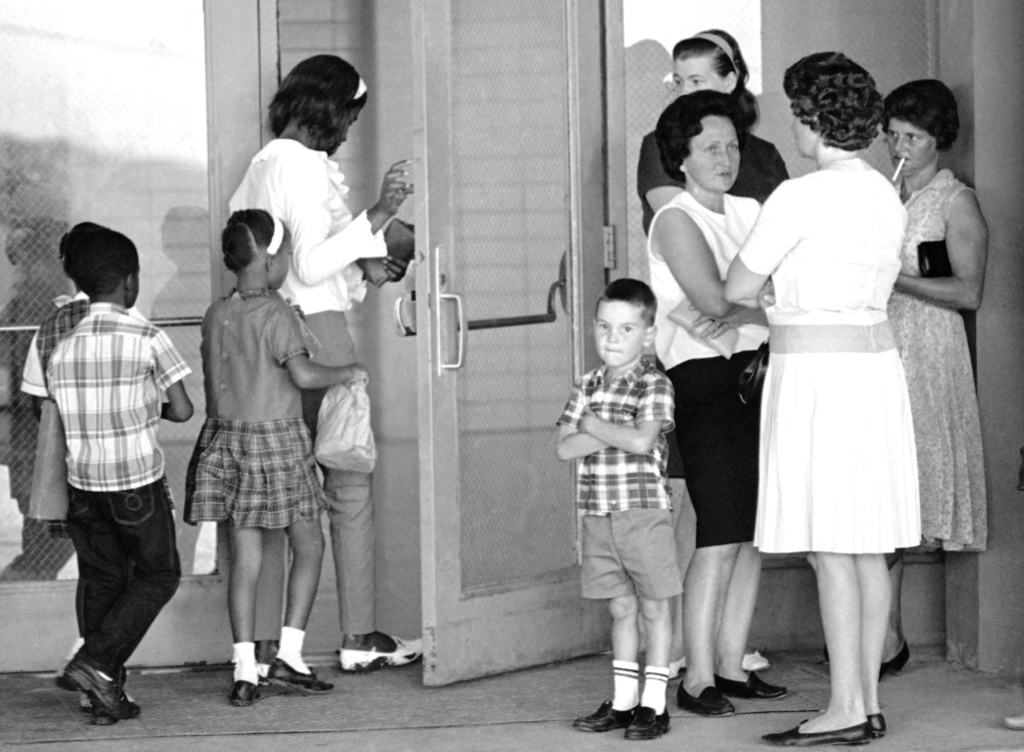 FILE - A group of African American students, left, enter the Boothville-Venice School in Plaquemines Parish, La., on Sept. 12, 1966, as a group of white mothers wait at the entrance of the school. (AP Photo/Jack Thornell, File)
