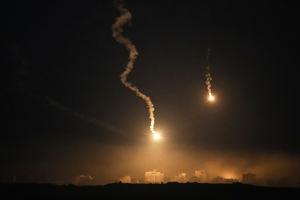 Flares drift over the Gaza Strip illuminates the nigh sky, as seen from southern Israel, Tuesday, Oct. 7, 2025. (AP Photo/Ohad Zwigenberg)
