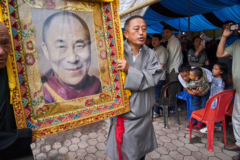 A Tibetan man and his child bow before a portrait of the Dalai Lama during celebrations marking the Tibetan spiritual leader's 91st birthday in Kathmandu, Nepal, Monday, July 6, 2026. (AP Photo/Niranjan Shrestha)