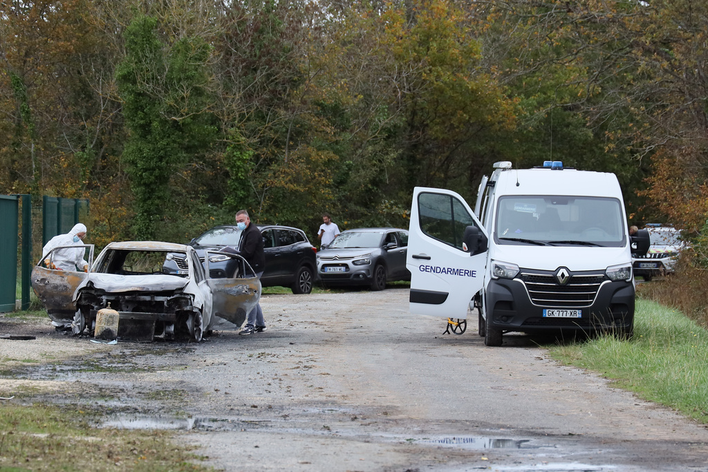 Investigators inspect the burned car after a motorist deliberately rammed pedestrians and cyclists across two neighbouring towns on the Ile d'Oleron, a quiet French island popular with tourists off the Atlantic coast, Wednesday, Nov. 5, 2025. (AP Photo/Yohan Bonnet)