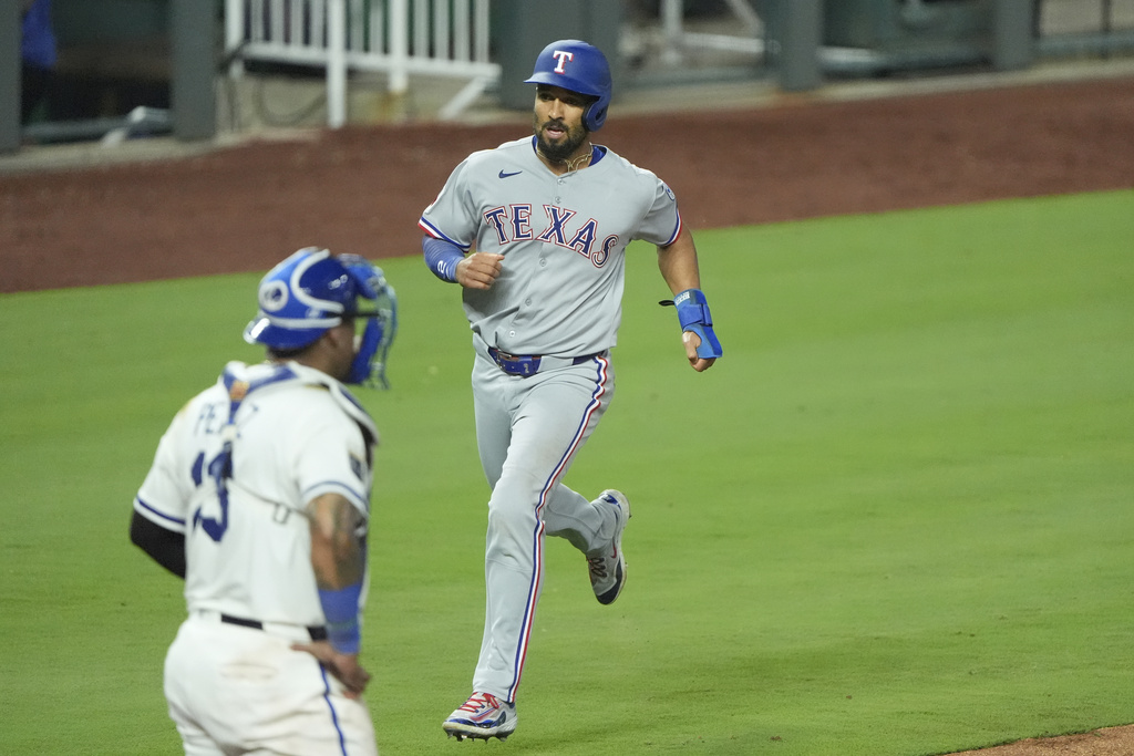 Texas Rangers' Marcus Semien runs home to score on a three-run double hit by Kyle Higashioka during the ninth inning of a baseball game against the Kansas City Royals, Wednesday, Aug. 20, 2025, in Kansas City, Mo. (AP Photo/Charlie Riedel)