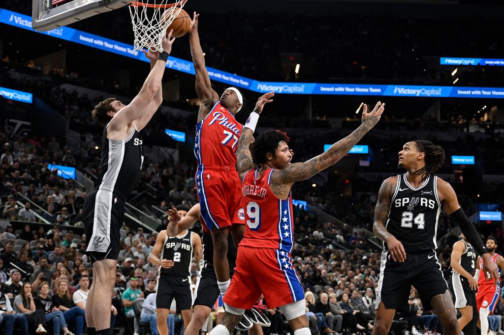 Philadelphia 76ers guard V.J. Edgecombe (77) goes to the basket against San Antonio Spurs center Luke Kornet, left, during the first half of an NBA basketball game, Monday, April 6, 2026, in San Antonio. (AP Photo/Darren Abate)