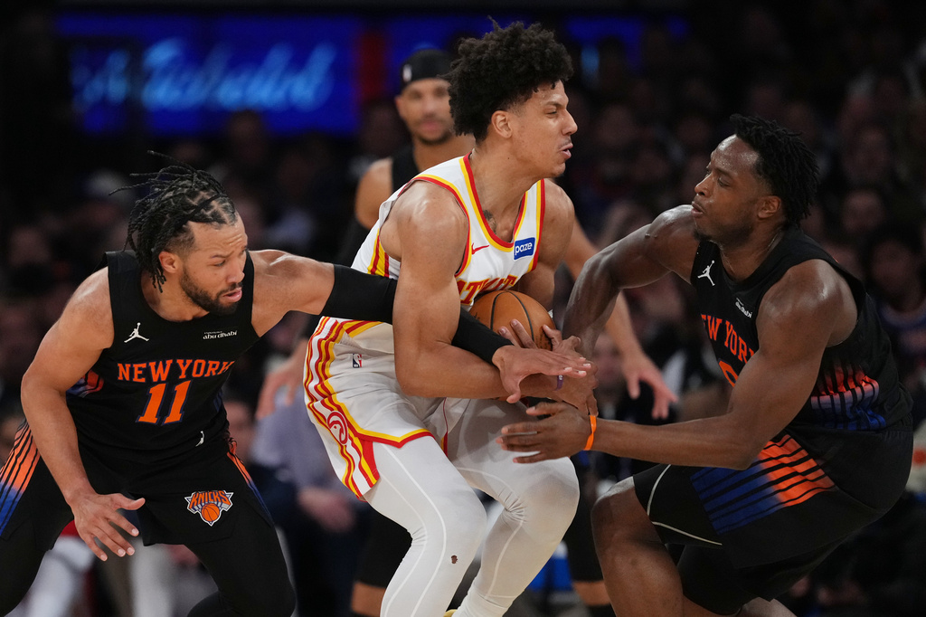 New York Knicks' Jalen Brunson, left, and OG Anunoby, right, defend Atlanta Hawks' Jalen Johnson, center, during the first half in Game 5 of a first-round NBA playoffs basketball series, Tuesday, April 28, 2026, in New York. (AP Photo/Frank Franklin II)