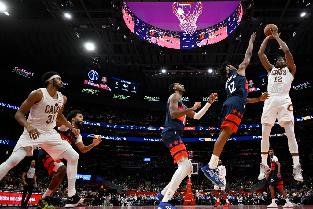 Cleveland Cavaliers forward De'Andre Hunter, right, takes a shot against Washington Wizards guard Tre Johnson (12) during the second half of an NBA Cup basketball game, Friday, Nov. 7, 2025, in Washington. (AP Photo/John McDonnell)