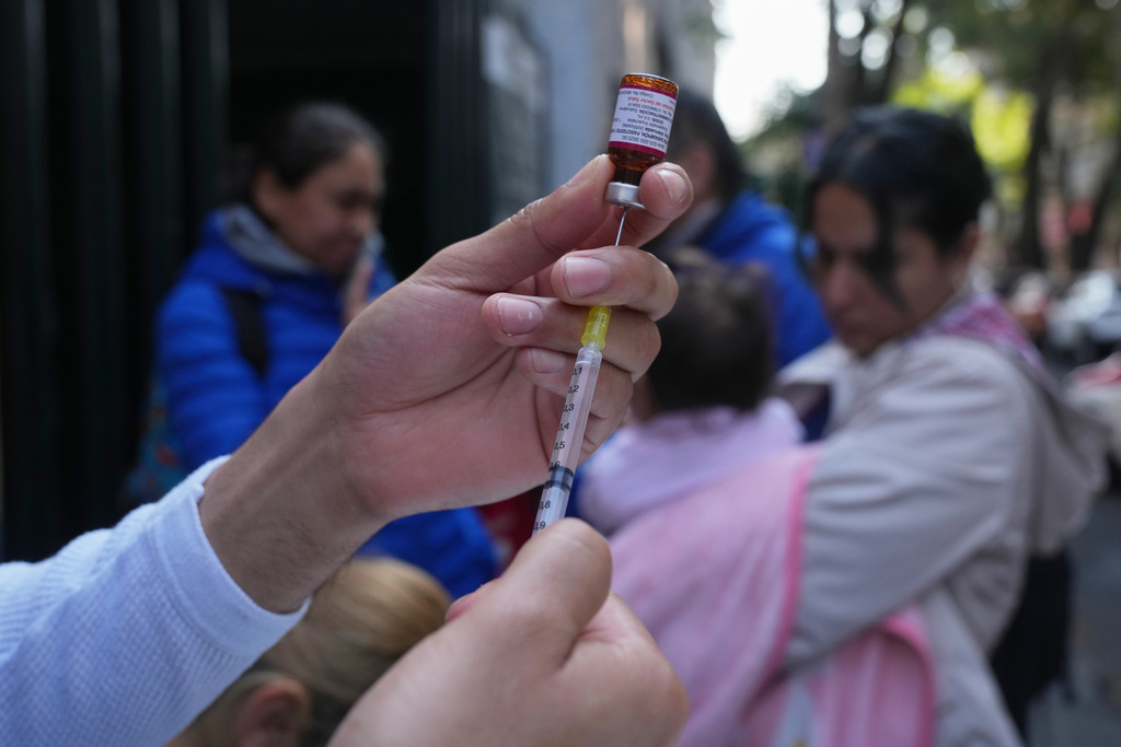 A health worker administers a dose of the measles vaccine outside a public hospital in Mexico City, Wednesday, Feb. 4, 2026. (AP Photo/Marco Ugarte)