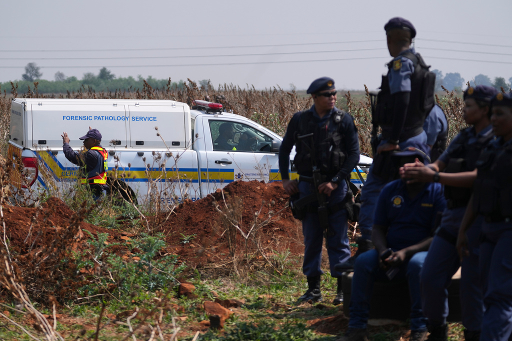 Forensic investigators work at the site where the body of a woman was discovered on the outskirts of Johannesburg, South Africa, Thursday, Sept. 17, 2026. (AP Photo/Themba Hadebe)