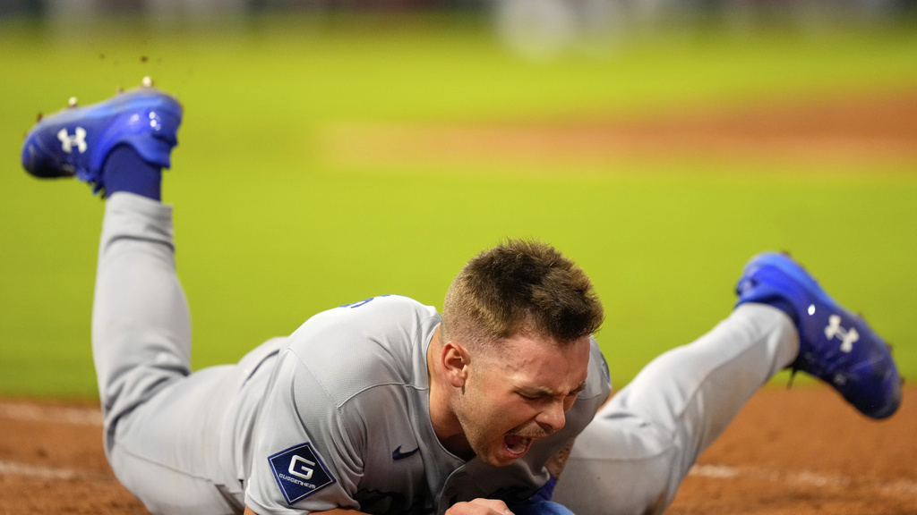 Los Angeles Dodgers' Dalton Rushing hits the ground after being tagged out in the last out of a triple play during the sixth inning of a baseball game Tuesday, Aug. 12, 2025, in Anaheim, Calif. (AP Photo/Mark J. Terrill)