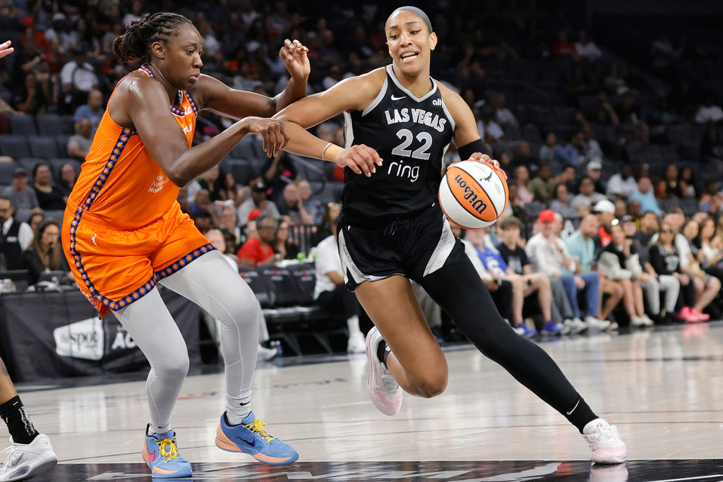 Las Vegas Aces center A'ja Wilson (22) drives against Connecticut Sun center Tina Charles, left, during the first half of a WNBA basketball game Sunday, Aug. 10, 2025, in Las Vegas. (Steve Marcus/Las Vegas Sun via AP)