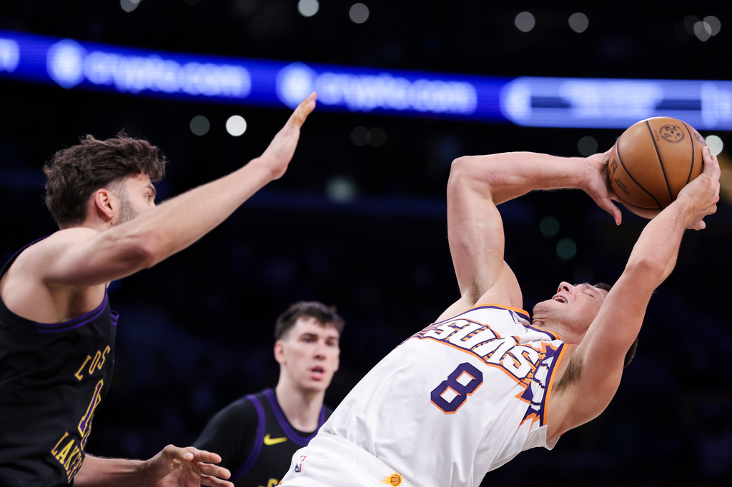 Phoenix Suns guard Grayson Allen (8) prepares to shoot against Los Angeles Lakers forward Maxi Kleber, left, as Lakers forward Jake LaRavia, back center, watches during the first half of an NBA basketball game, Friday, April 10, 2026, in Los Angeles. (AP Photo/Jessie Alcheh)
