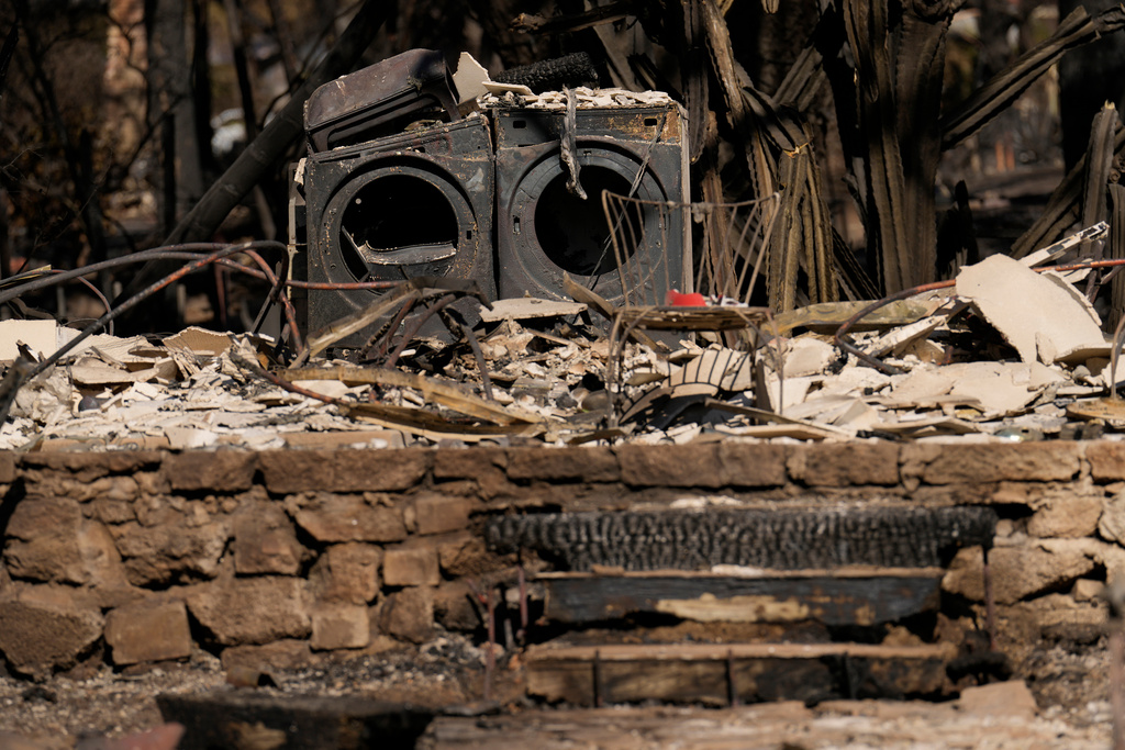 FILE - A burned washer and dryer are among the remains of a home destroyed by the Eaton Fire, Monday, Jan. 13, 2025, in Altadena, Calif. (AP Photo/Carolyn Kaster, File)