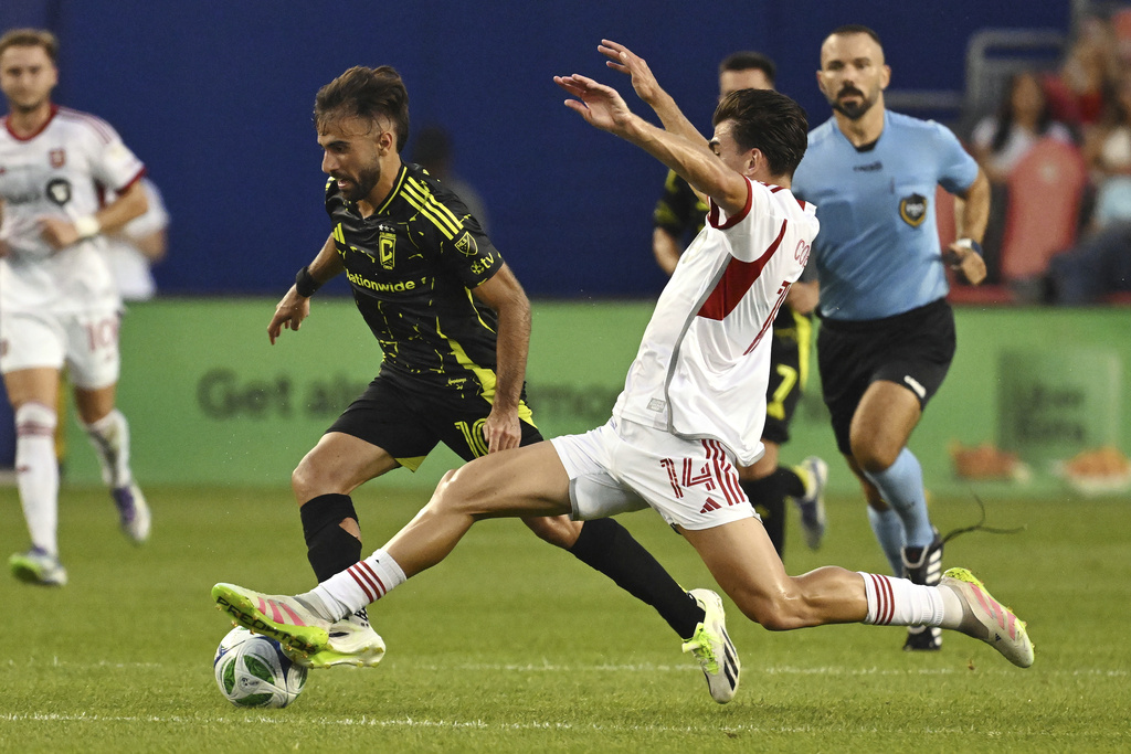 Columbus Crew's Diego Rossi, left, moves the ball past Toronto FC's Alonso Coello during first-half MLS soccer action in Toronto, Saturday, Aug. 16, 2025. (Jon Blacker/The Canadian Press via AP)