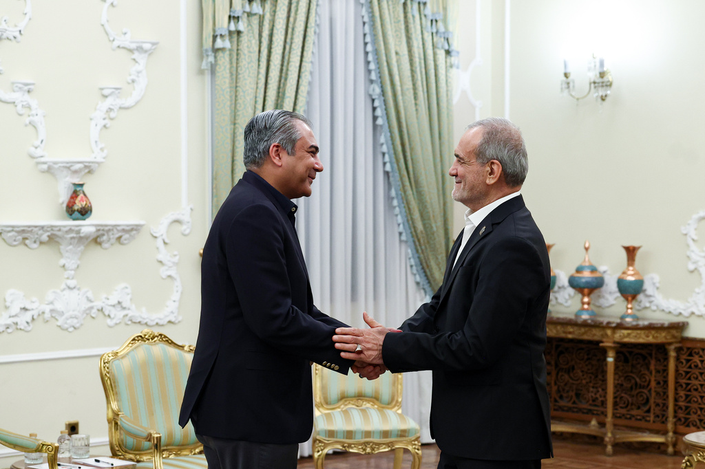 In this photo released by the Iranian Presidency Office, Iranian President Masoud Pezeshkian, right, greets Pakistan's Interior Minister Mohsin Naqvi at the start of their meeting in Tehran, Iran, Tuesday, Aug. 11, 2026. (Iranian Presidency Office via AP)