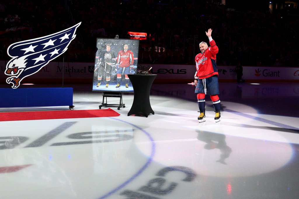 Washington Capitals left wing Alex Ovechkin (8) waves during a pregame ceremony honoring him for scoring 900 goals and playing in 1,500 games for a single franchise before an NHL hockey game against the Winnipeg Jets, Wednesday, Nov. 26, 2025, in Washington. (AP Photo/Nick Wass)
