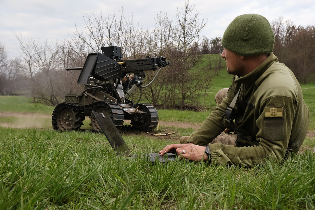 In this photo provided by Ukraine's 65th Mechanised Brigade press service on April 10, 2026, a Ukrainian serviceman prepares a machine gun on a combat ground drone during a training at the polygon in Zaporizhzhia region, Ukraine. (Andriy Andriyenko/Ukraine's 65th Mechanised Brigade via AP)
