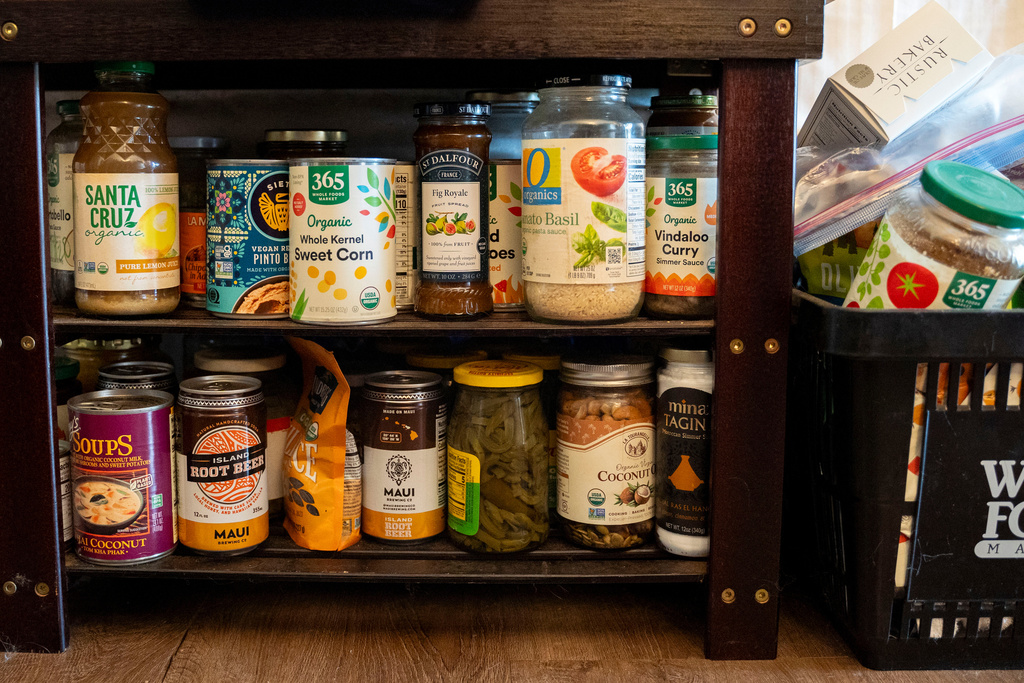 Dry goods purchased with support from a monthly cash assistance program sit in the converted hotel room where Mari Younger lives after being displaced by the Maui fires two years prior, in Kihei, Hawaii, Wednesday, March 4, 2026. (AP Photo/Mengshin Lin)