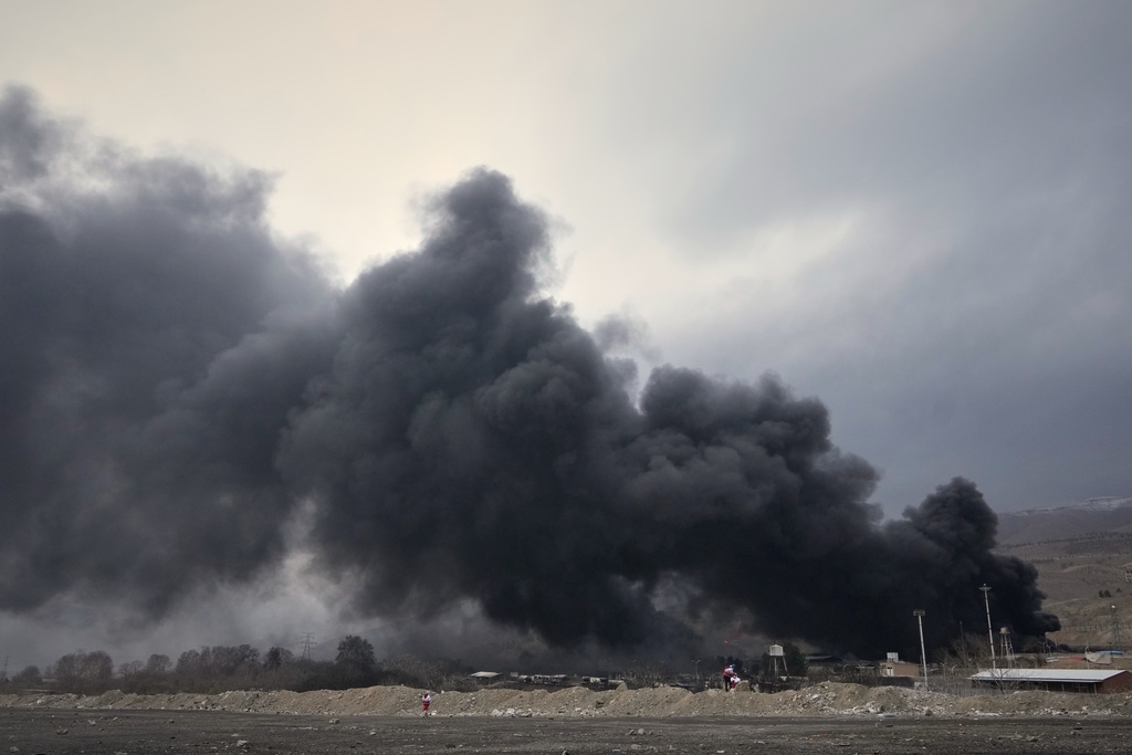 A thick plume of smoke rises from an oil storage facility hit by a U.S.-Israeli strike late Saturday in Tehran, Iran, Sunday, March 8, 2026. (AP Photo/Vahid Salemi)
