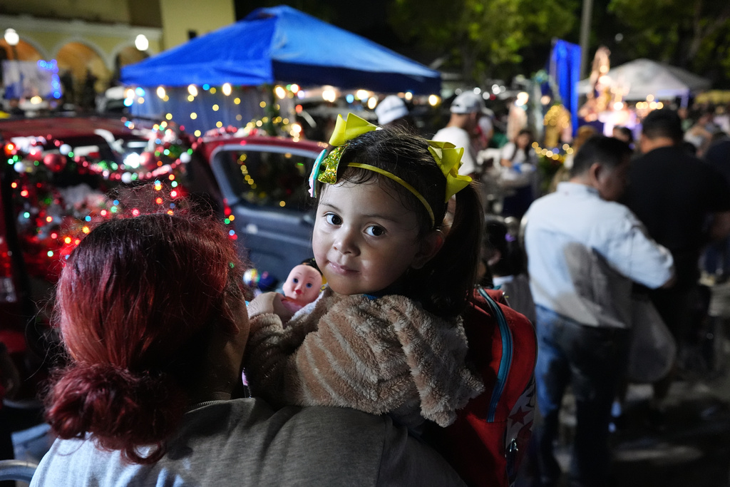 A little girl holds a doll, one of many gifts distributed at dozens of open-air altars to the Virgin Mary, as Nicaraguan parishioners of St. John Bosco Catholic Church celebrate the Dec. 8 feast of the Immaculate Conception, Sunday, Dec. 7, 2025, in Miami. (AP Photo/Rebecca Blackwell)