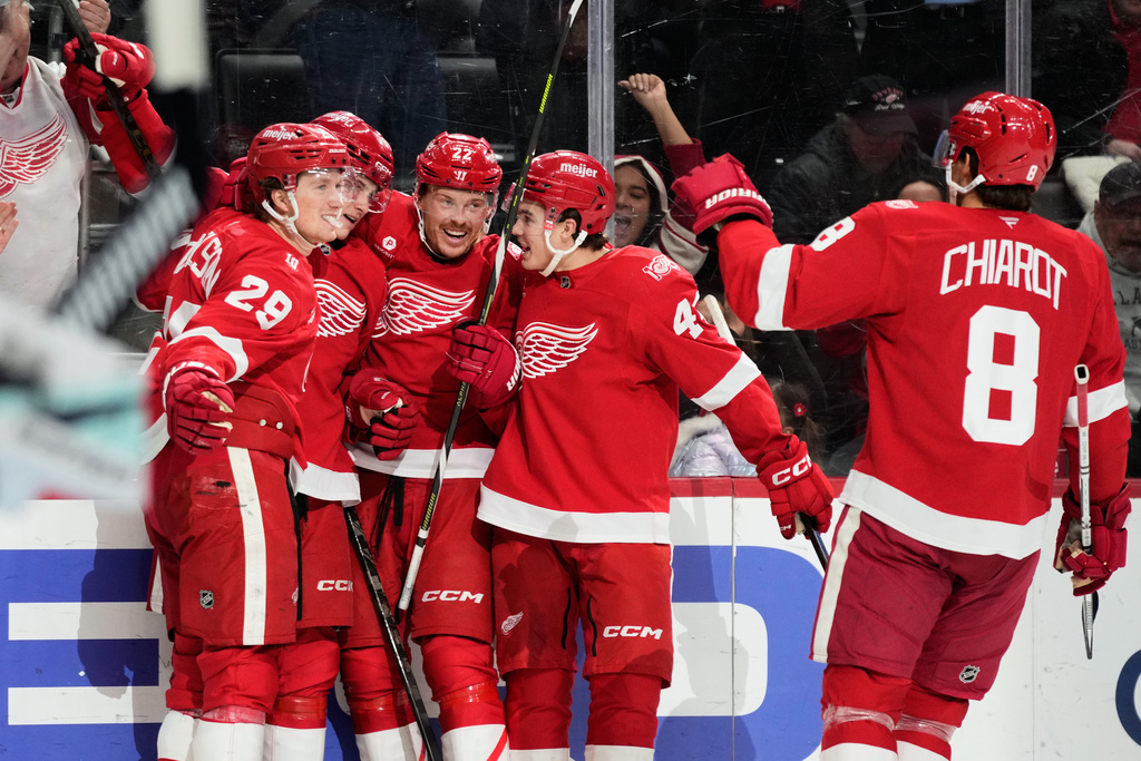 Detroit Red Wings center Nate Danielson, left, celebrates with teammates after scoring, a goal that on review was overturned on an off-side call, during the second period of an NHL hockey game against the Seattle Kraken, Tuesday, Nov. 18, 2025, in Detroit. (AP Photo/Ryan Sun)