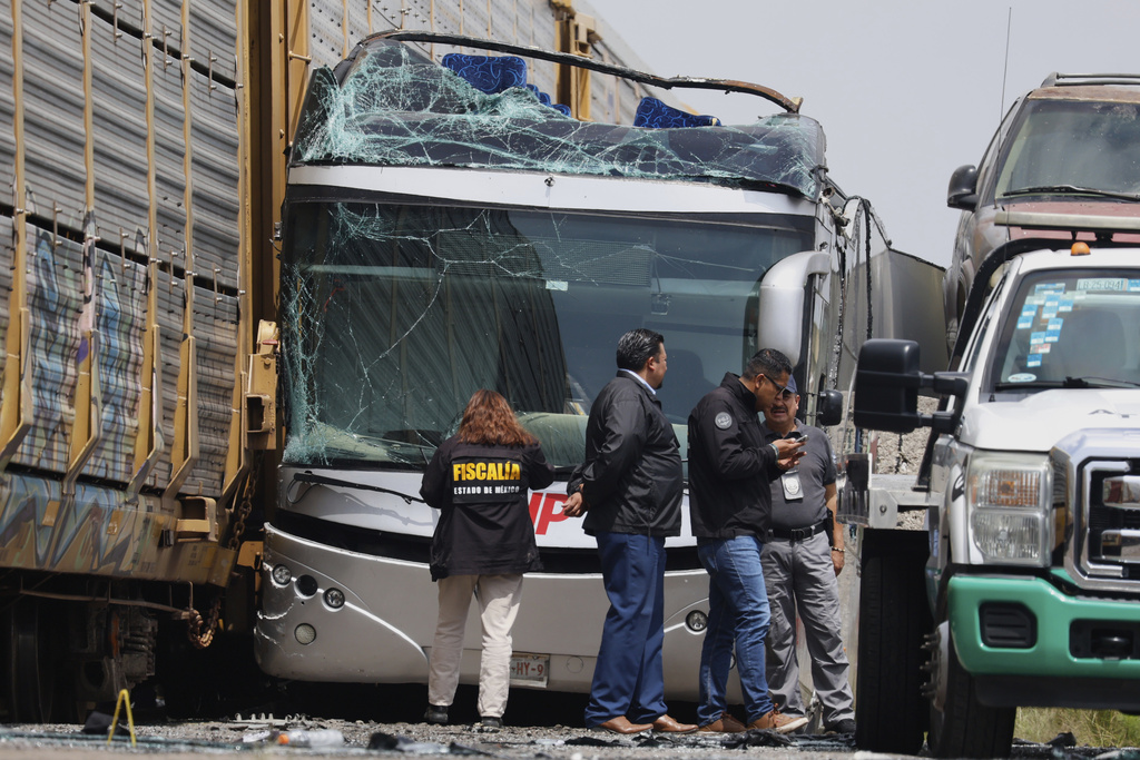 Investigators work at the scene of a deadly accident where a freight train slammed into a double-deck bus in Atlacomulco, Mexico, Monday, Sept. 8, 2025. (AP Photo/Ramses Mercado Valdes)