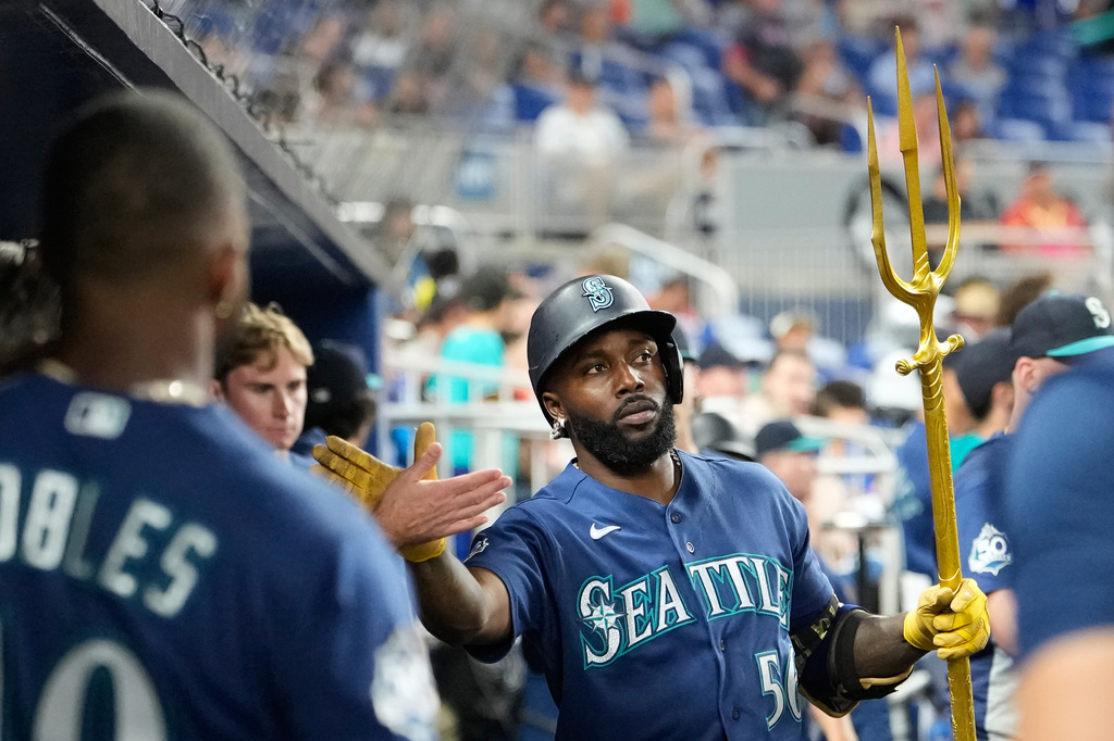 Seattle Mariners' Randy Arozarena (56) is congratulated in the dugout after hitting a solo home run during the fifth inning of a baseball game against the Miami Marlins, Thursday, July 9, 2026, in Miami. (AP Photo/Lynne Sladky)
