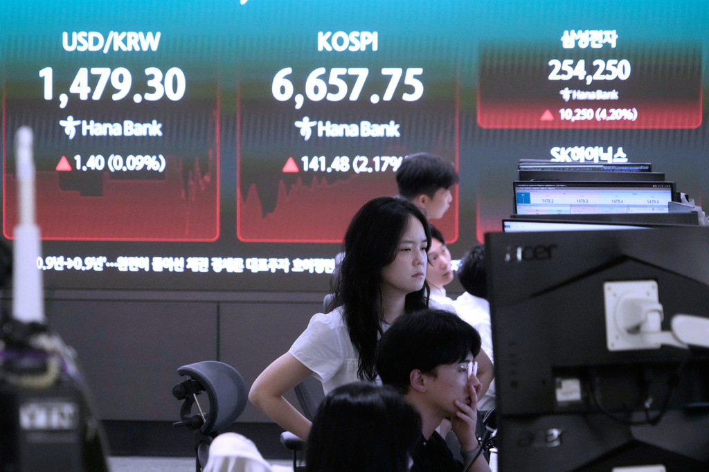 Currency traders watch monitors near a screen showing the Korea Composite Stock Price Index (KOSPI) and the foreign exchange rate between U.S. dollar and South Korean won at the foreign exchange dealing room of the Hana Bank headquarters in Seoul, South Korea, Tuesday, July 21, 2026. (AP Photo/Ahn Young-joon)