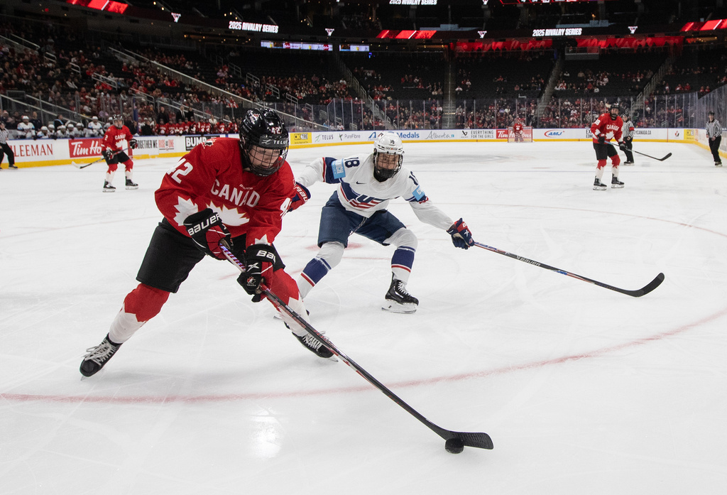 United States' Jesse Compher (18) chases Canada's Claire Thompson (42) during third period Rivalry Series action in Edmonton on Wednesday, Dec. 10, 2025. (Jason Franson/The Canadian Press via AP)