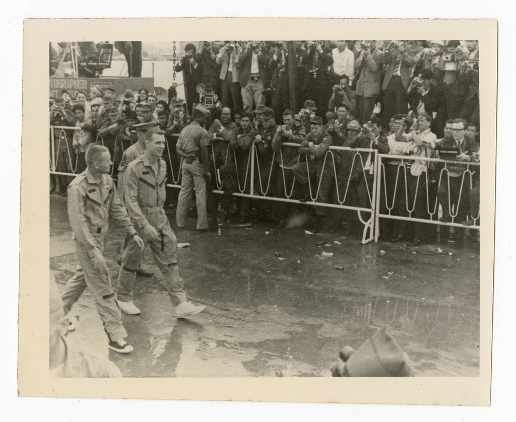 This 1966 photo taken by Ron McQueeney shows astronauts Neil Armstrong (left) and David Scott walking through a crowd of U.S. service members at Naha Air Base in Okinawa, Japan.