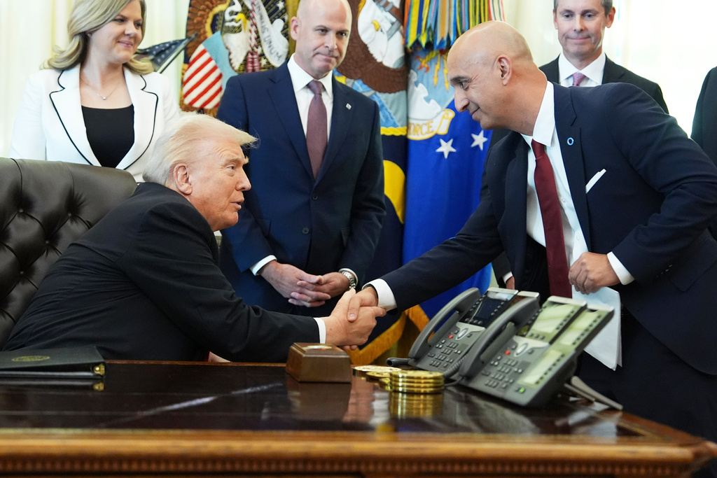 President Donald Trump, left, shakes the hand of Novo Nordisk President and CEO Mike Doustdar during an event about drug prices, Thursday, Nov. 6, 2025, in the Oval Office of the White House in Washington. (AP Photo/Evan Vucci)