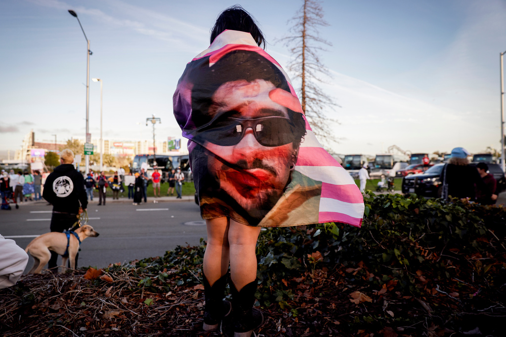Kenia Medal wears a Bad Bunny flag while waiting to watch the halftime show outside Levi's Stadium during the NFL Super Bowl 60 football game between the Seattle Seahawks and the New England Patriots in Santa Clara, Calif., Sunday, Feb. 8, 2026. (Brontë Wittpenn/San Francisco Chronicle via AP)