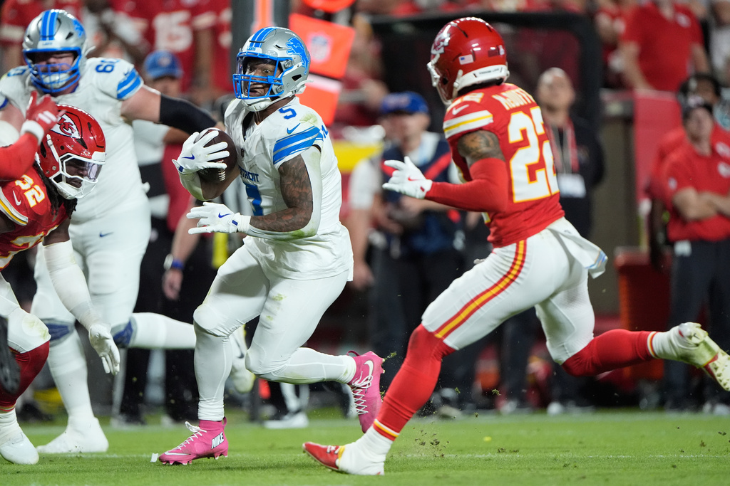 Detroit Lions running back David Montgomery, left, runs for a first down as Kansas City Chiefs cornerback Trent McDuffie (22) defends during the second half of an NFL football game Sunday, Oct. 12, 2025, in Kansas City, Mo. (AP Photo/Charlie Riedel)