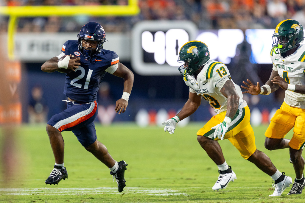 Virginia running back Jekail Middlebrook (21) runs with the ball past Norfolk State linebacker Brendan Thompson (13) during an NCAA college football game on Friday, Sept. 11, 2026, in Charlottesville, VA. (AP Photo/Mike Kropf)