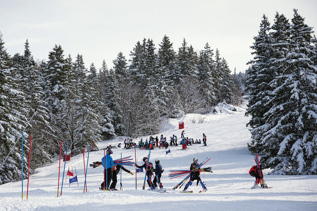 Coach Jeremie Barnier and his athletes remove the stakes after a training ski session in Lans-en-Vercors, near Grenoble, France, Friday, Feb. 13, 2026. (AP Photo/Laurent Cipriani)