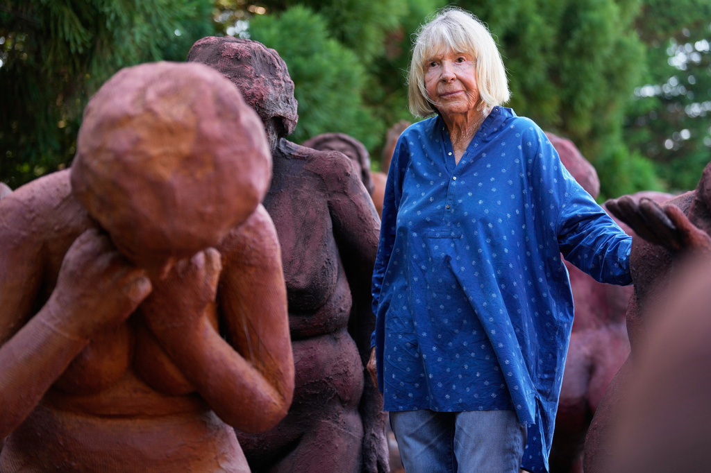 Artist Suse Lowenstein, whose son, Alex, was killed in the bombing of Pan Am Flight 103 over Lockerbie, Scotland, poses for a photograph amongst the figures thats make up her sculpture titled "Dark Elegy" in her backyard in Montauk, N.Y., Wednesday, Aug. 19, 2026. (AP Photo/Seth Wenig)