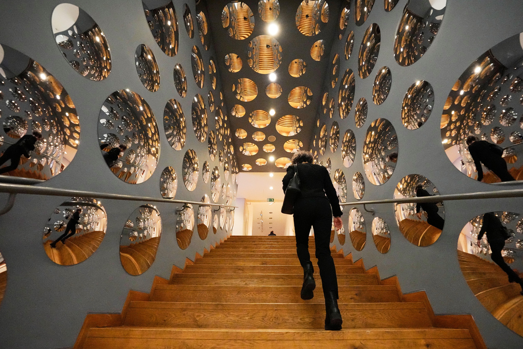 A woman walks through the art installation 'Invisible Life" during a preview of the new major exhibition of legendary Japanese artist Yayoi Kusama at the Museum Ludwig in Cologne, Thursday, March 12, 2026. (AP Photo/Martin Meissner)