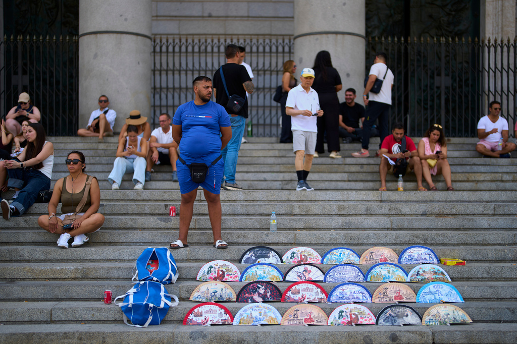 A street vendor sells fans near the Royal Palace in Madrid, Spain, on Aug. 20, 2026. (AP Photo/Manu Fernandez)