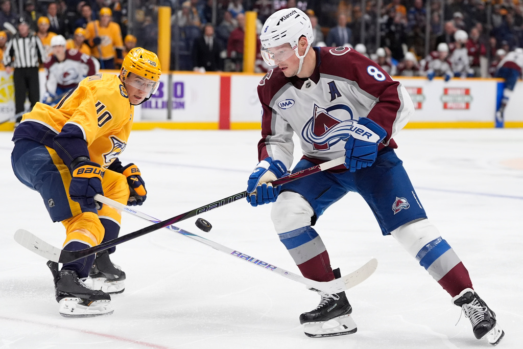 Colorado Avalanche defenseman Cale Makar (8) moves the puck past Nashville Predators center Fedor Svechkov (40) during the third period of an NHL hockey game Tuesday, Dec. 9, 2025, in Nashville, Tenn. (AP Photo/George Walker IV)