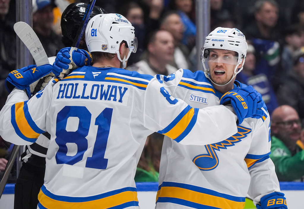 St. Louis Blues' Pius Suter (22) and Dylan Holloway (81) celebrate Suter's goal during the second period of an NHL hockey game against the Vancouver Canucks in Vancouver, Saturday, March 21, 2026. (Darryl Dyck/The Canadian Press via AP)