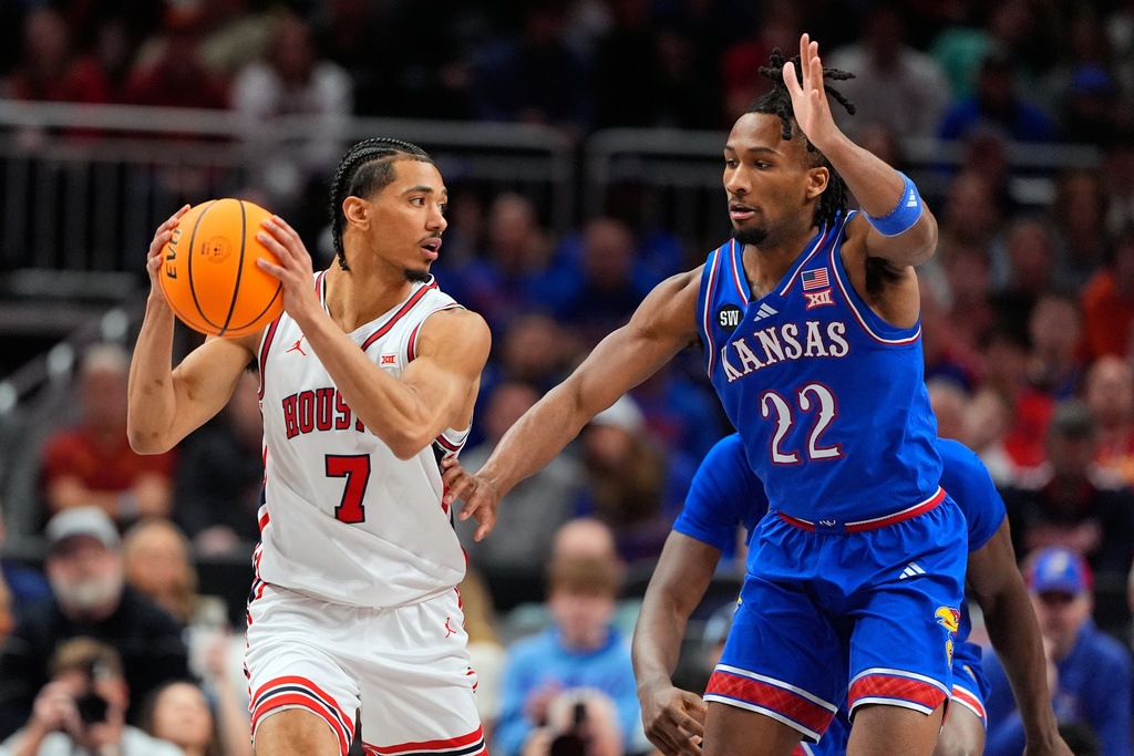 Houston's Milos Uzan (7) looks to pass as Kansas' Darryn Peterson (22) defends during the first half of an NCAA college basketball game in the semifinal round of the Big 12 Conference tournament Friday, March 13, 2026, in Kansas City, Mo. (AP Photo/Charlie Riedel)