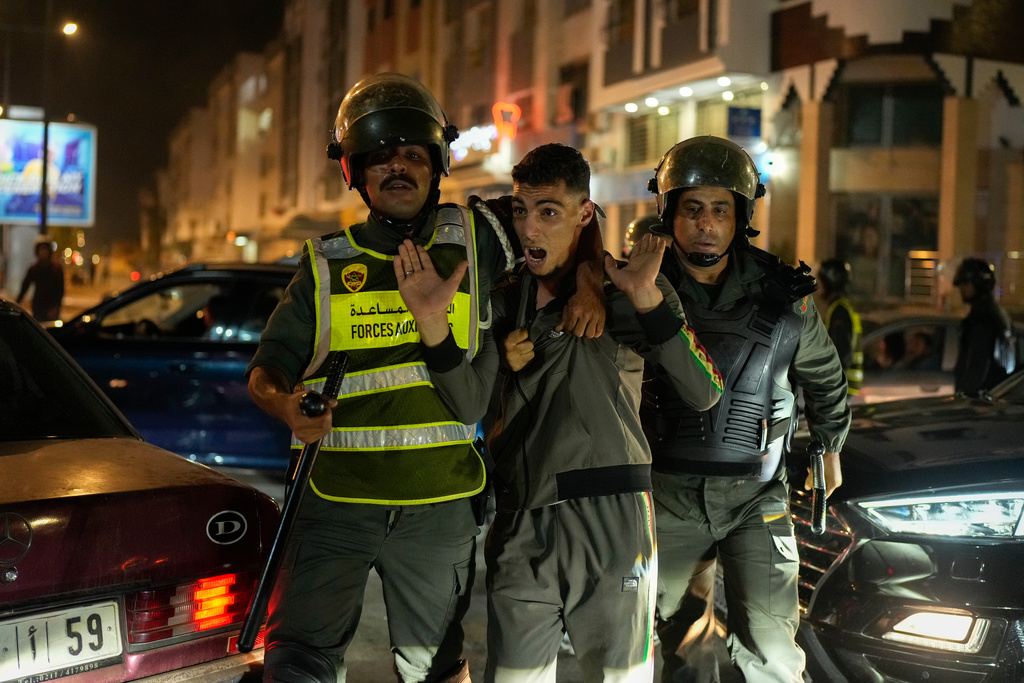 A boy is detained as youth led protests calling for healthcare and education reforms turned violent, in Sale, Morocco, Wednesday, Oct. 1, 2025. (AP Photo/Mosa'ab Elshamy)