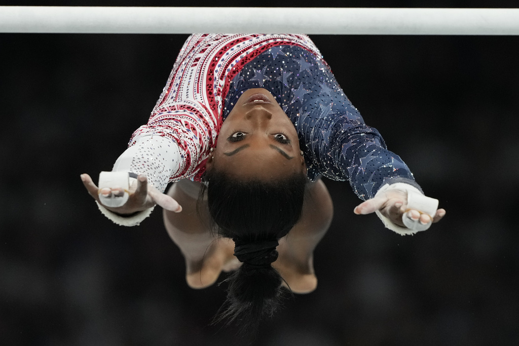 Simone Biles, of the United States, performs on the uneven bars during the women's artistic gymnastics team finals round at Bercy Arena at the 2024 Summer Olympics, Tuesday, July 30, 2024, in Paris, France. (AP Photo/Natacha Pisarenko)