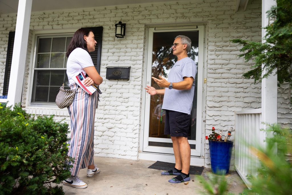 Denise Powell, left, the Democratic candidate for the House of Representatives in Nebraska's second congressional district, chats with Andy Maxwell on his doorstep in Omaha, Neb., Saturday, Aug. 15, 2026. (AP Photo/Rebecca S. Gratz)