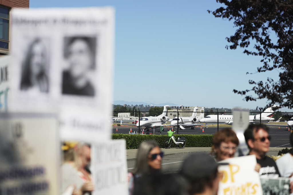 Parked aircrafts are seen on the tarmac as protesters hold a news conference outside of Boeing Field airport in King County, Tuesday, July 15, 2025, in Seattle. (AP Photo/Ryan Sun)