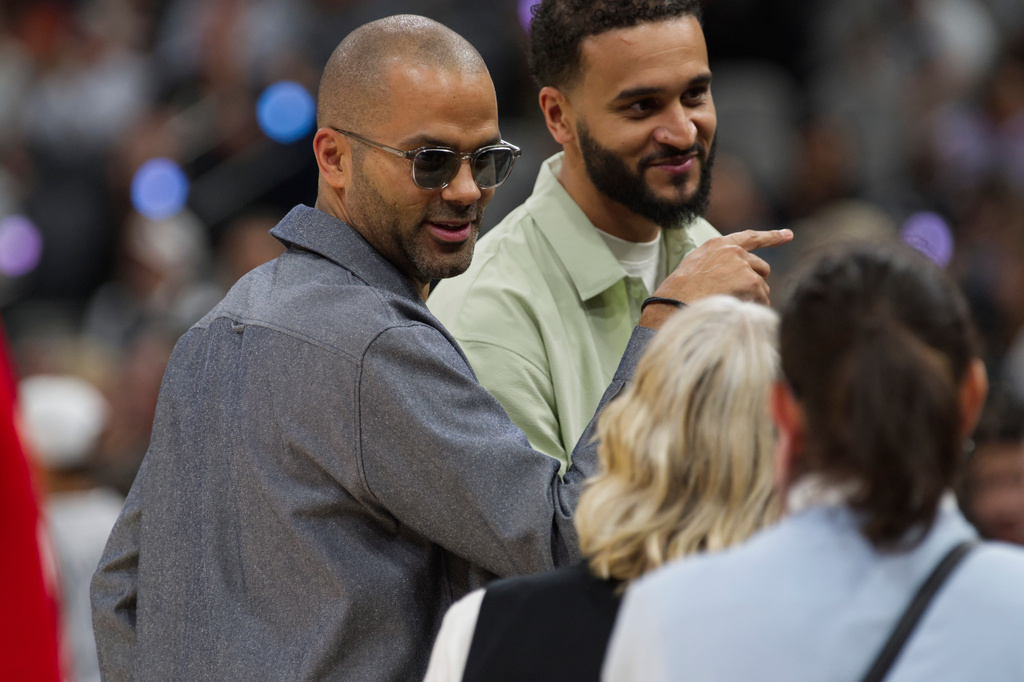 Former San Antonio Spurs guard Tony Parker, left, speaks with fans before an NBA basketball game against the Toronto Raptors, Monday, Oct. 27, 2025, in San Antonio. (AP Photo/Darren Abate)