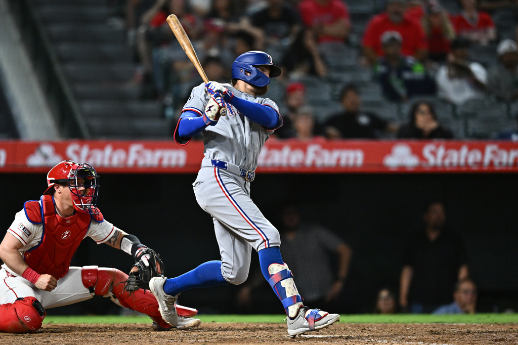Texas Rangers' Brandon Nimmo, right, hits an RBI single during the 10th inning of a baseball game against the Los Angeles Angels, Monday, Aug. 10, 2026, in Anaheim, Calif. (AP Photo/William Liang)