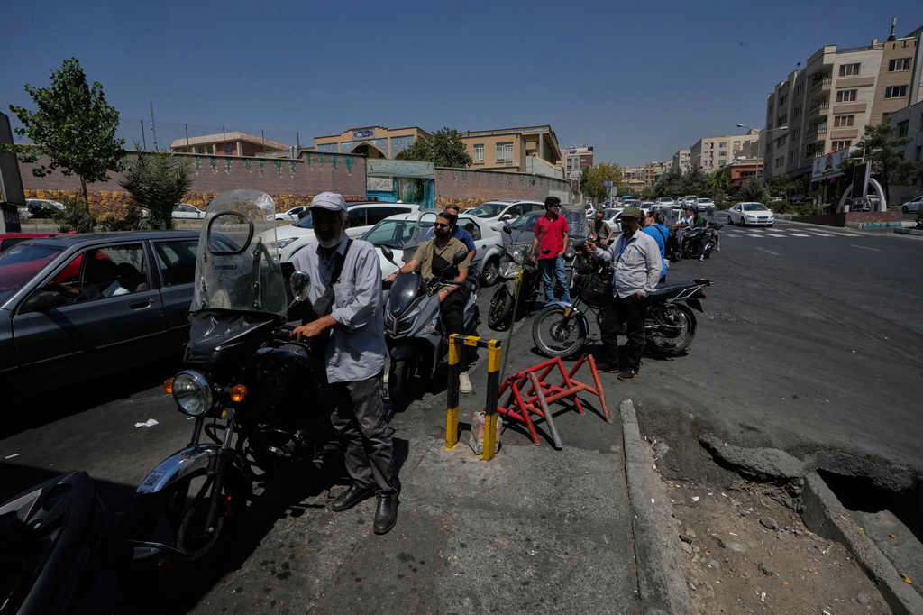 Motorcycles and cars line up outside a gas station in Tehran, Iran, Tuesday, Aug. 25, 2026. (AP Photo/Vahid Salemi)