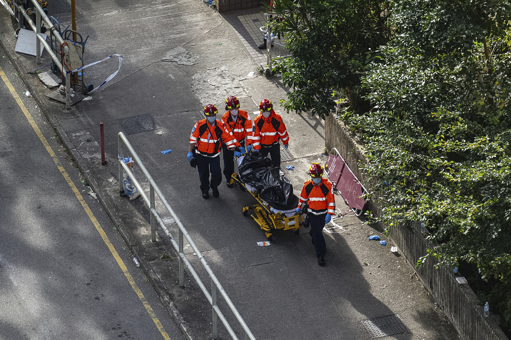 Health workers remove a body after a deadly fire Wednesday at Wang Fuk Court, a residential estate in the Tai Po district of Hong Kong's New Territories, Friday, Nov. 28, 2025. (AP Photo/Chan Long Hei)