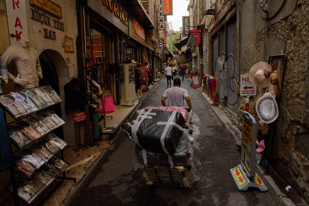 A man pulls a trolley loaded with goods through Istanbul's Eminonu commercial district, Tuesday, Aug. 11, 2026. (AP Photo/Francisco Seco)