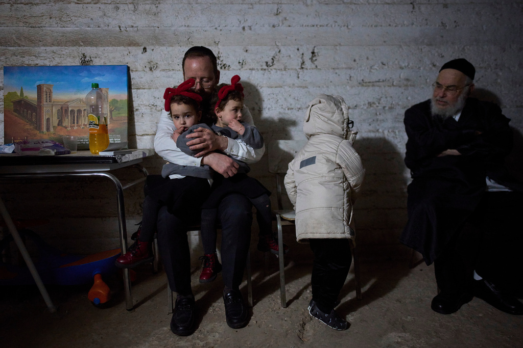 People take cover in a bomb shelter as air raid sirens warn of incoming Iranian missile strikes in Bnei Brak, Israel, Wednesday, March 25, 2026. (AP Photo/Ohad Zwigenberg)